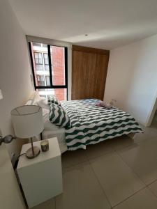 Un dormitorio con una cama y una lámpara y una ventana. en Ocean View Total Comfort, en Manta