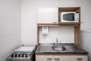eine kleine Küche mit Spüle und Mikrowelle in der Unterkunft Studio Solar de Copacabana Vista Mar in Rio de Janeiro + 12 Fotos