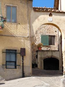 a building with an archway next to a building at La Dimora di Dida in Seggiano