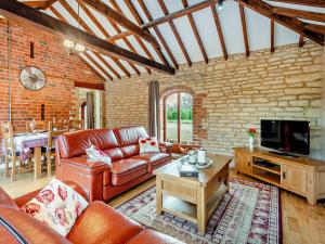 a living room with a leather couch and a tv at 2 Bed in Digby 91059 in Ashby de la Launde