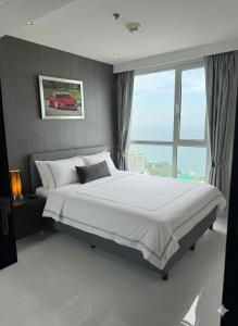 ein Schlafzimmer mit einem großen Bett und einem großen Fenster in der Unterkunft Sky residences - Plage de Pattaya Pratamnak Moderne in Pattaya South + 8 Fotos