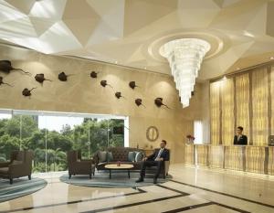 Ein Mann, der auf einer Couch in der Lobby sitzt. in der Unterkunft Sky residences - Plage de Pattaya Pratamnak Moderne in Pattaya South