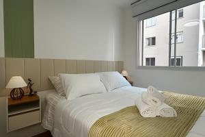 um quarto com uma cama com duas toalhas em O mais completo Studio com sacada prox Tokio Marine Hall em São Paulo