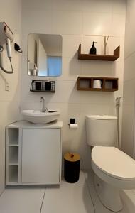 um banheiro branco com um vaso sanitário e uma pia em O mais completo Studio com sacada prox Tokio Marine Hall em São Paulo mais 72 fotografias