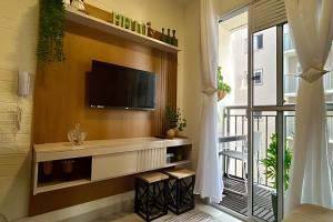 uma sala de estar com uma televisão e uma varanda em O mais completo Studio com sacada prox Tokio Marine Hall em São Paulo