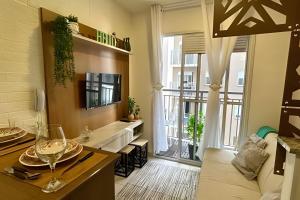 uma cozinha e sala de estar com uma mesa e um sofá em O mais completo Studio com sacada prox Tokio Marine Hall em São Paulo