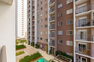 uma vista para um edifício de apartamentos a partir de uma janela em O mais completo Studio com sacada prox Tokio Marine Hall em São Paulo