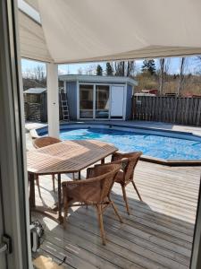 eine Terrasse mit Tisch und Stühlen neben einem Swimmingpool in der Unterkunft Gamla Hjälmarvägen 10 in Örebro