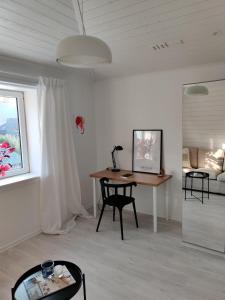 Zimmer mit einem Schreibtisch, einem Tisch und einem Sofa in der Unterkunft Gamla Hjälmarvägen 10 in Örebro