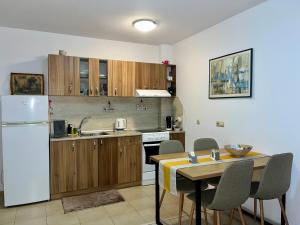 a kitchen with a table and a white refrigerator at Cozy apartment Alba with two bedrooms! in Blagoevgrad