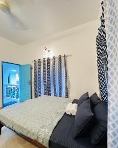 a bedroom with a bed and a blue door at Lima Beach House Varkala in Varkala +15 photos