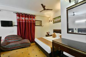 a bedroom with a bed and a desk and a mirror at Hotel Blue Star - Paharganj Delhi in New Delhi