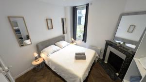 Schlafzimmer mit einem Bett, einem Kamin und einem Spiegel in der Unterkunft Le Nid Auxerrois in Auxerre