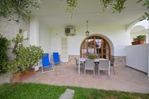 a patio with a table and blue chairs at Appartamenti Ischia la Sentinella in Ischia