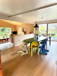 a dining room with a green table and yellow chairs at Wonderful Family House At The West Coast in Løkken