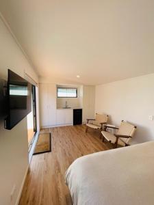 a bedroom with a bed and a table and chairs at The Coconut Hut Papamoa Beach in Tauranga