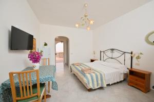 a bedroom with a bed and a table and a tv at Appartamenti Ischia la Sentinella in Ischia +90 photos