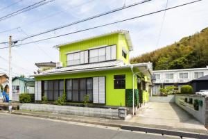 Casa Stay 7 - Vacation STAY 25344v的街上的一座黄色和白色的房子