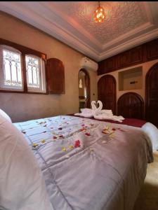 マラケシュにあるCharmant Riad avec piscine, au Coeur de Marrakechの花が飾られた大きなベッドのある寝室 +19枚の写真