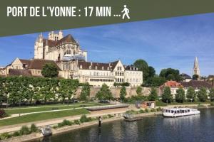 ein Bild von einem großen Gebäude mit einem Boot im Wasser in der Unterkunft Le Nid Auxerrois in Auxerre