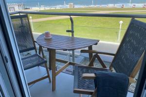 a table and chairs on a balcony with a view of the beach at Fewo Gestrandet in Norderney