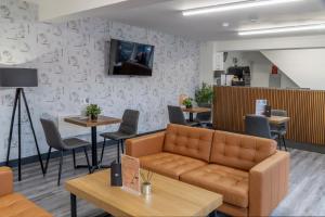 a waiting room with a couch and tables at Dockside Aparthotel, Best Western Signature Collection in Liverpool