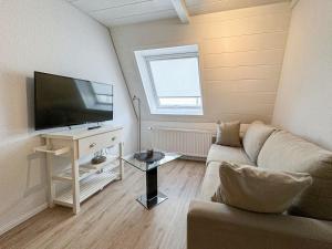 a living room with a couch and a flat screen tv at Kaffeehaus - Fewo 3 in Norderney