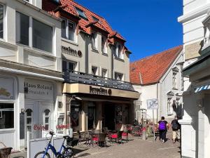 a couple of people walking down a street with buildings at Kaffeehaus - Fewo 3 in Norderney