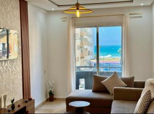 Una sala de estar con un sofá y una ventana grande. en Super appart vue sur mer, en Rabat