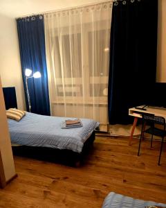 a bedroom with a bed and a desk and a window at Perłowy in Biłgoraj