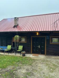 een huis met een rood dak met stoelen en een tafel bij Hiža Bake Veronike in Hrašćina