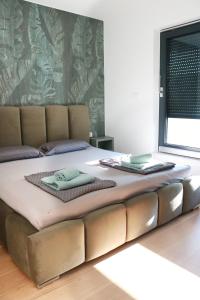 ein großes Bett mit zwei Handtüchern darüber in der Unterkunft Royal Rest Apartments Karlovac in Karlovac + 80 Fotos