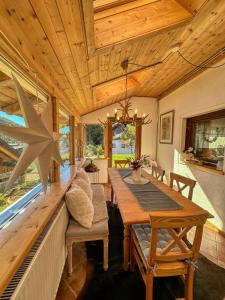 a dining room with a table and a large window at Sunny apartment Ula, close to Brunnachbahn in Sankt Oswald
