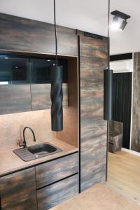 eine Küche mit Spüle und großer Schiebetür in der Unterkunft Royal Rest Apartments Karlovac in Karlovac