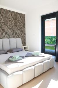 ein großes weißes Bett in einem Zimmer mit Fenster in der Unterkunft Royal Rest Apartments Karlovac in Karlovac