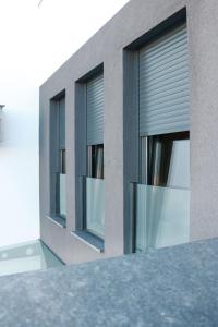 zwei Fenster an einem Gebäude mit Jalousien in der Unterkunft Royal Rest Apartments Karlovac in Karlovac