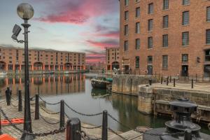 a river with a boat in a city with buildings at Dockside Aparthotel, Best Western Signature Collection in Liverpool
