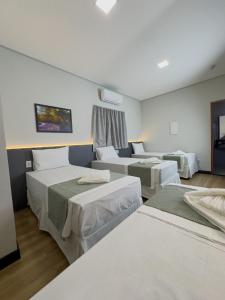 a room with three beds in a room at Nature Bonito Hotel in Bonito