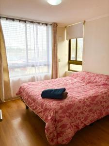 une chambre avec un lit avec une couverture rouge dans l'établissement Hermoso depto Céntrico, atención Empresas Facturas, à Chillán