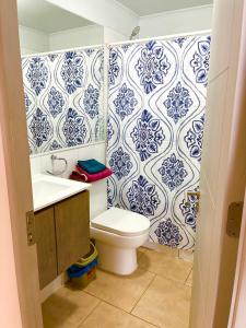 une salle de bains avec toilettes et carrelage bleu et blanc dans l'établissement Hermoso depto Céntrico, atención Empresas Facturas, à Chillán 6 autres photos