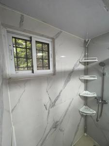 a bathroom with white marble walls and a window at Mar azul 401 in San Felipe de Puerto Plata
