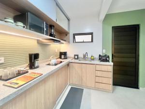 a kitchen with wooden cabinets and a counter top at Apartamento de curta temporada - ótimo padrão - próximo Lagoa de Iriry in Rio das Ostras
