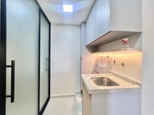 a small kitchen with a sink next to a door at Apartamento de curta temporada - ótimo padrão - próximo Lagoa de Iriry in Rio das Ostras