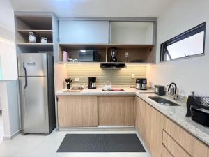 a kitchen with a stainless steel refrigerator and cabinets at Apartamento de curta temporada - ótimo padrão - próximo Lagoa de Iriry in Rio das Ostras