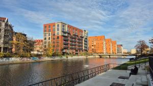 een rivier in een stad met gebouwen en een brug bij Sarantis Apartment in Old Town Gdansk in Gdańsk