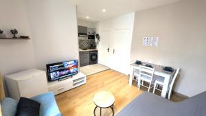 a living room with a blue couch and a kitchen at Le cosy nest in Auxerre