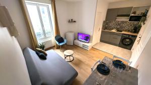 a small living room with a table and a kitchen at Le cosy nest in Auxerre