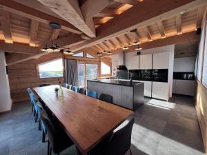 een eetkamer met een grote houten tafel en stoelen bij Chalet Téléporté in Les Gets
