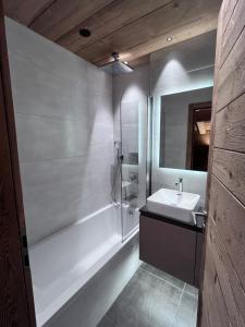 een badkamer met een bad en een wastafel en een ligbad bij Chalet Téléporté in Les Gets +71 foto's