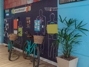 a wall with two bikes parked next to a plant at ibis budget Maceió Pajuçara in Maceió
